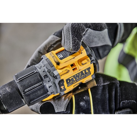 Close-up of a gloved hand adjusting the speed setting on a DEWALT 18V XR brushless cordless drill.