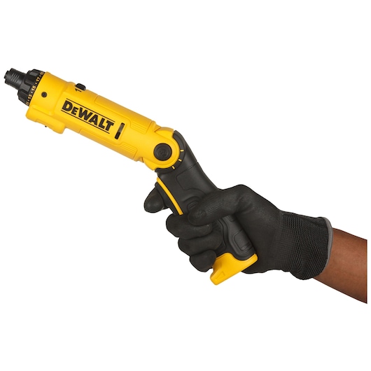 A person wearing a black work glove is holding a yellow and black DEWALT cordless screwdriver.
