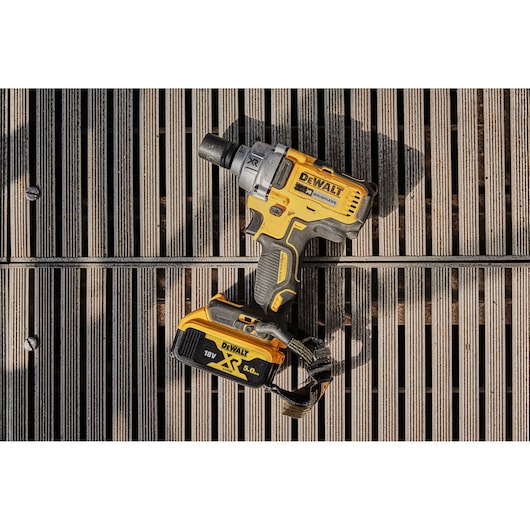 DEWALT cordless impact wrench DCF894P2 with battery, placed on a wooden plank surface outdoors.