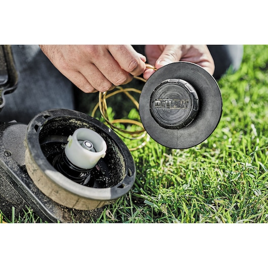 DEWALT DCZ65713X1-XE and DCMAS5713N parts being assembled on grass in close-up outdoor view.