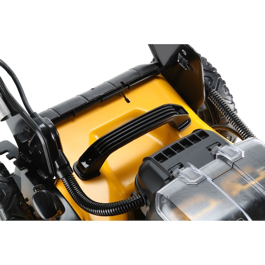 Close-up of DEWALT lawn mower handle and battery compartment on yellow body, showing sturdy build.