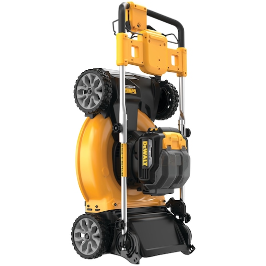 A DEWALT cordless lawn mower in a vertical storage position, showing a yellow and black design with large wheels and a visible battery compartment.