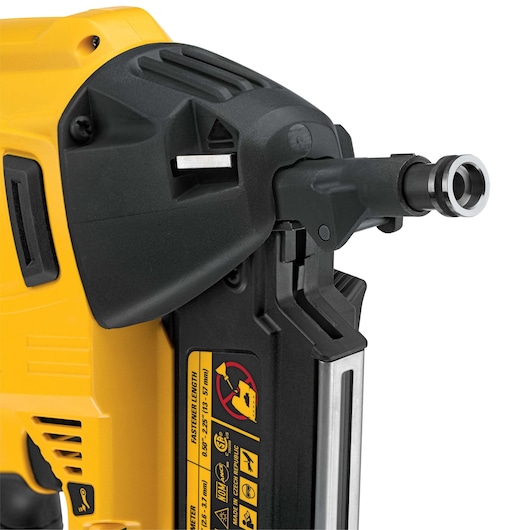 Close-up of a DEWALT nail gun showing safety labels and part of the barrel.