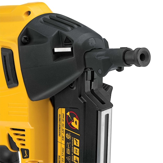 Close-up of a DEWALT nail gun showing the nozzle and safety instructions on the side.