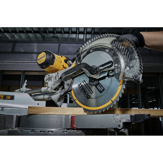 DEWALT circular saw in action cutting a piece of wood indoors, close-up of blade and motor.