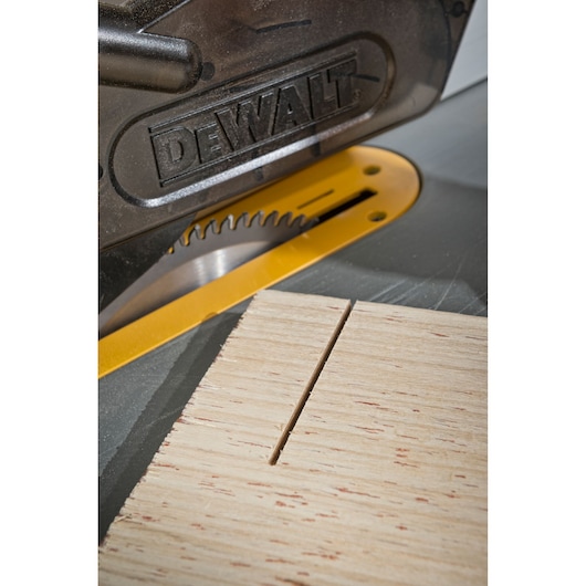 Close-up of a DEWALT circular saw cutting a wooden board, showing the blade and fresh cut.