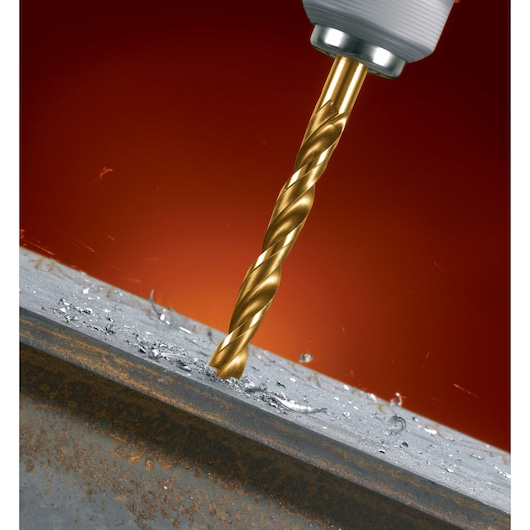 A close-up of a DEWALT drill bit boring into a piece of metal, with metal shavings scattered around the drilled area against a red background.