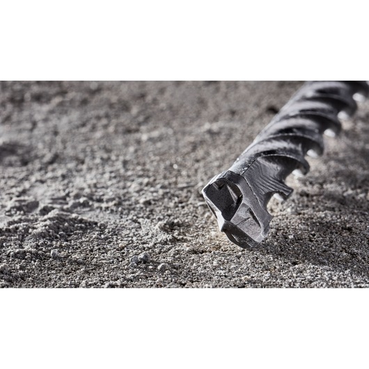 Close-up of a DEWALT DT8961 masonry drill bit resting on rough concrete surface.