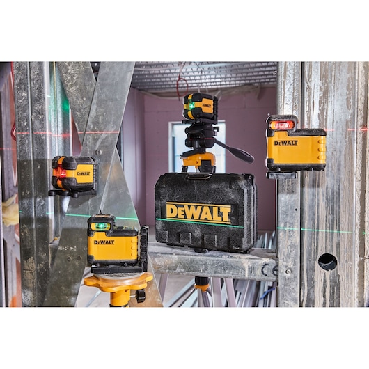 DEWALT laser levels and carrying case are set up at a construction site with visible green and red laser lines.