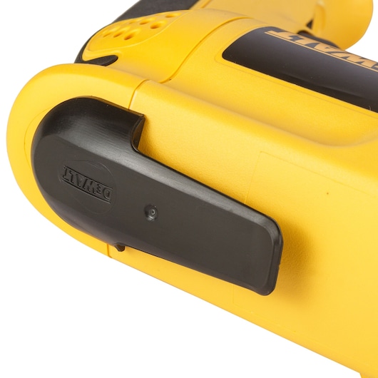Close-up of a yellow DEWALT power tool with a black clip attachment on its side.
