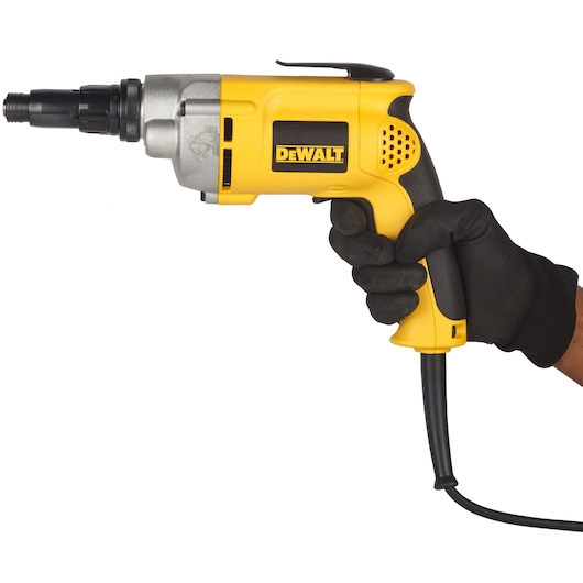 A yellow DEWALT electric screwdriver (model DW268) is shown with a black glove holding it, featuring a power cord and trigger handle, photographed against a white background.