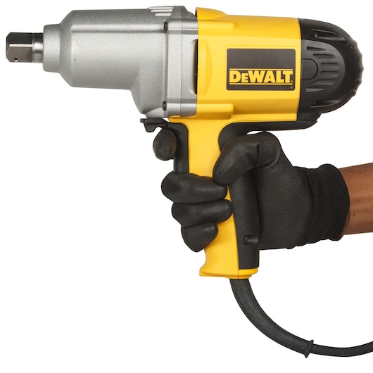 A person wearing a black glove is holding a yellow and black DEWALT electric impact wrench with a cord, shown against a white background.