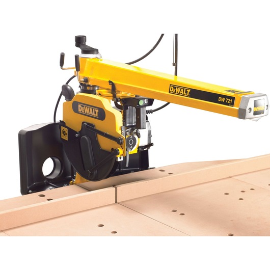 DEWALT DW721 radial arm saw cutting wood on a workbench with a yellow arm and black motor housing.