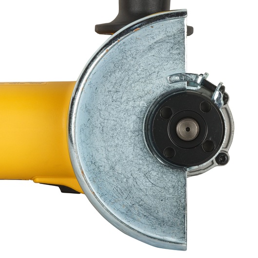 Close-up of a DEWALT angle grinder with a metal guard and yellow casing.