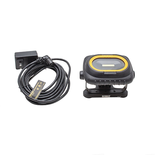 DEWALT portable LED work light with a sturdy black and yellow casing, shown alongside a power adapter and a coiled cable.