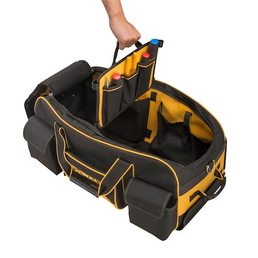 Hand lifting an organizer from a DEWALT tool bag with yellow trim and multiple storage pockets.