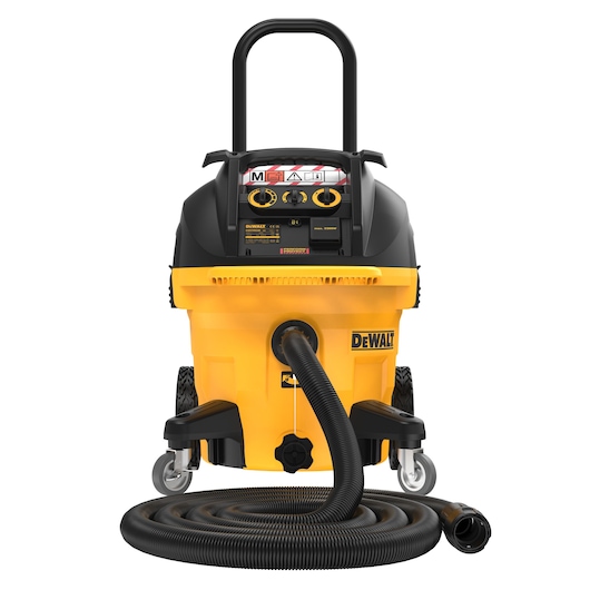 Front view of a DEWALT DWV905M industrial vacuum cleaner with a yellow and black body, large handle, wheels, and a long flexible hose coiled on the ground.